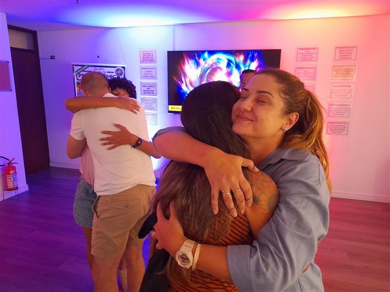 Alunos se abraçando ao final de uma dinâmica da Formação Practitioner em PNL