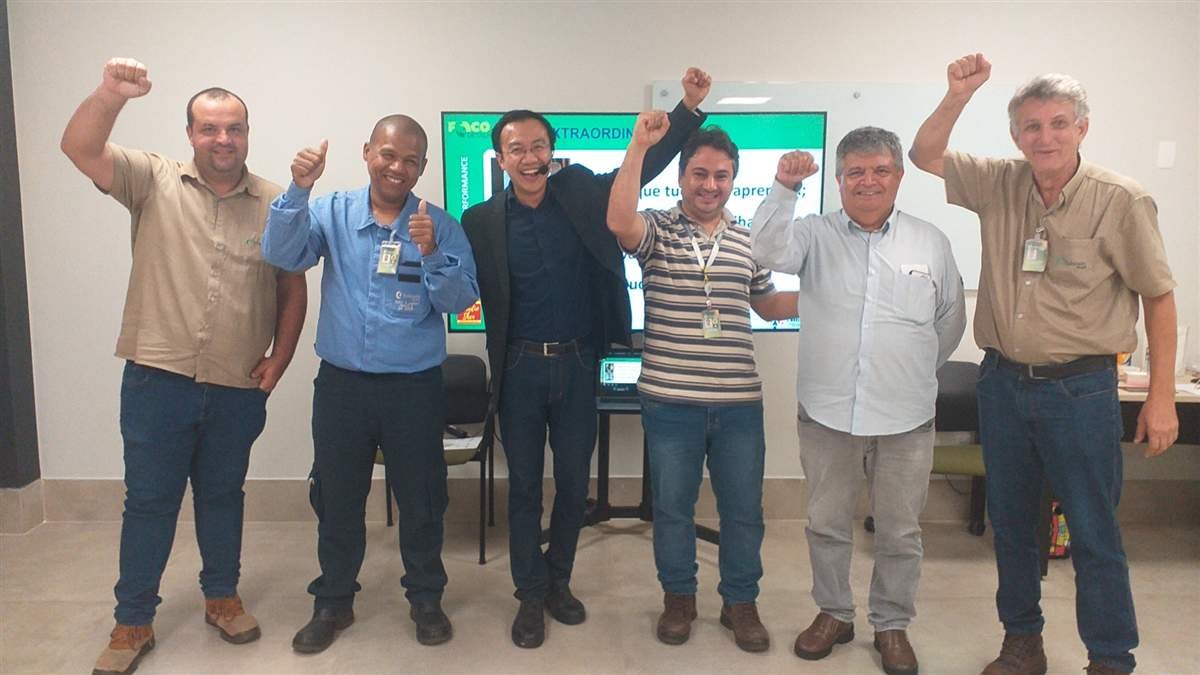 Líderes e gestores celebrando o aprendizado ao lado de Claudio Shen em um treinamento de liderança