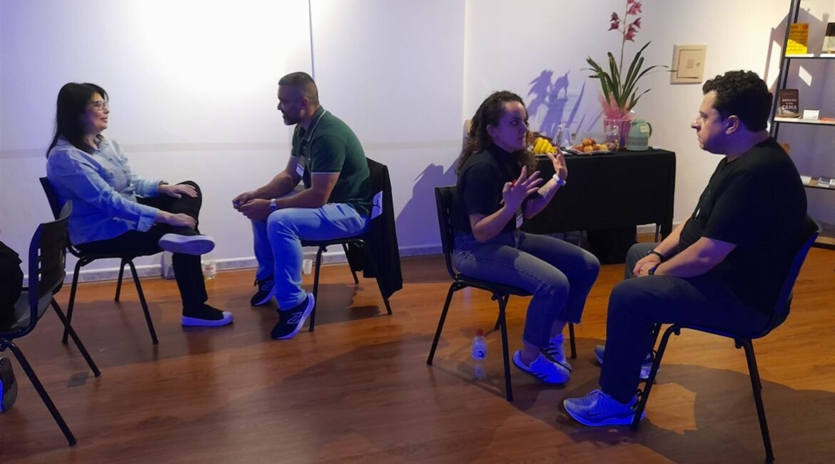 Alunos em exercício de escuta em duplas no curso de oratória com PNL