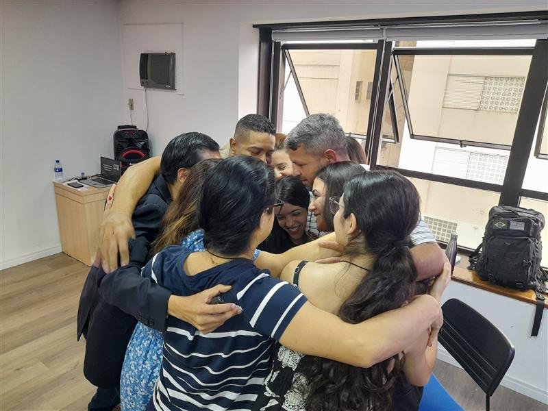 Participantes do Seminário de Inteligência Emocional com PNL em um abraço em grupo