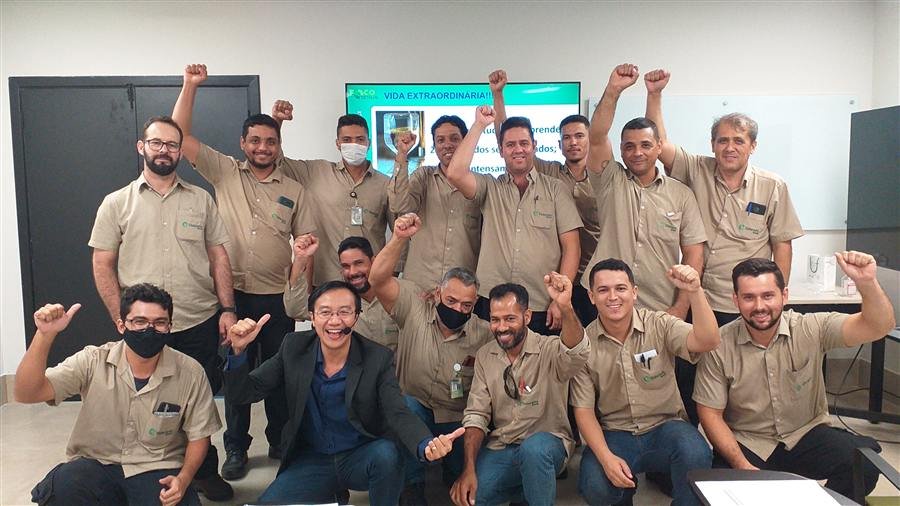 Equipe uniformizada celebrando ao final de um treinamento corporativo com PNL