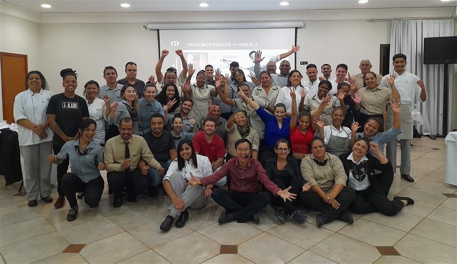 Turma grande de colaboradores em dinâmica de treinamento corporativo